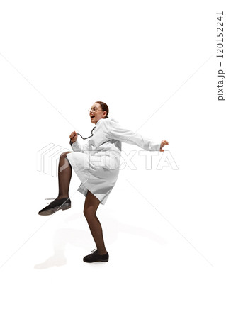 Dynamic photo of young woman, doctor in full gear, with stethoscope, dancing because she cured patient against white studio background. 120152241