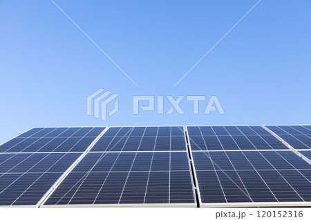 Aerial view of solar panel cells on clear blue sky background. Alternative energy concept. Modern house with solar panels stand-alone photovoltaic plant system on household metal sheet roof 120152316