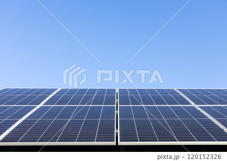 Aerial view of solar panel cells on clear blue sky background. Alternative energy concept. Modern house with solar panels stand-alone photovoltaic plant system on household metal sheet roof Aerial view of solar panel cells on clear blue sky background. Alternative energy concept. Modern house with solar panels stand-alone photovoltaic plant system on household metal sheet roof 120152326