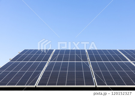 Aerial view of solar panel cells on clear blue sky background. Alternative energy concept. Modern house with solar panels stand-alone photovoltaic plant system on household metal sheet roof 120152327