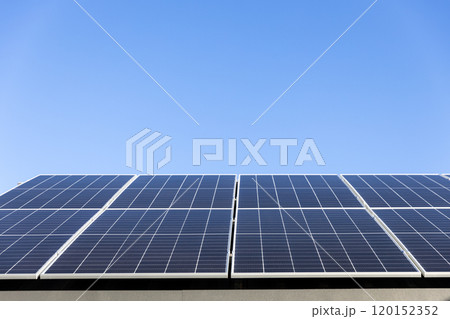 Aerial view of solar panel cells on clear blue sky background. Clean alternative energy power concept, sustainable resources. Modern house, solar panels stand-alone photovoltaic plant system on roof 120152352