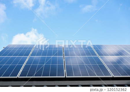 Solar panel cells on cloudy blue sky background. Clean alternative energy power concept. Modern house with solar panels stand-alone photovoltaic plant system on metal sheet roof. Go green 120152362