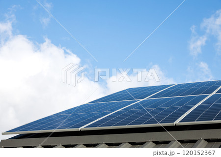 Aerial view of solar panel cells against cloudy blue sky. Alternative energy concept, sustainable resources. House with solar panels stand-alone photovoltaic plant system. Professional installation 120152367