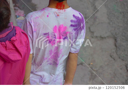 Person with colored powder hand print on t-shirt in pink and purple hues showing the traditional vibrant Holi Festival in Pokhara Nepal Person with colored powder hand print on t-shirt in pink and purple hues showing the traditional vibrant Holi Festival in Pokhara Nepal 120152506