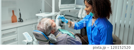 Dentist gently performs dental check-up, making patient feel comfortable and cared for. Her calm demeanor helps ease any patient anxiety. Dentist gently performs dental check-up, making patient feel comfortable and cared for. Her calm demeanor helps ease any patient anxiety. 120152520