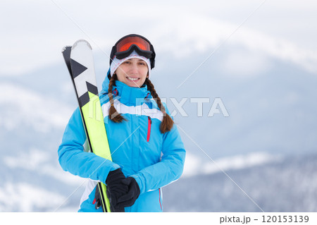 Skiing Woman Poses With Ski Equipment in Snowy Mountain Landscape 120153139