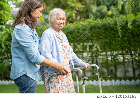 Doctor caregiver help and care Asian senior woman patient walk with walker in park at hospital. Doctor caregiver help and care Asian senior woman patient walk with walker in park at hospital. 120153165