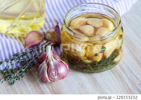 Garlic cloves pickled in sunflower oil and thyme. 120153232