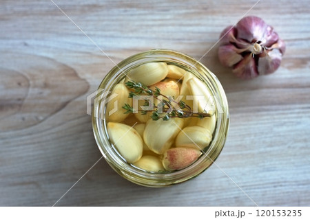 Garlic cloves pickled in sunflower oil and thyme. Garlic cloves pickled in sunflower oil and thyme. 120153235