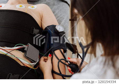 Medical staff monitoring patients blood pressure and vitals during a health assessment Medical staff monitoring patients blood pressure and vitals during a health assessment 120154334