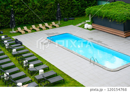 Luxury resort hotel garden with swimming pool and sun loungers, sun loungers by the pool 120154768