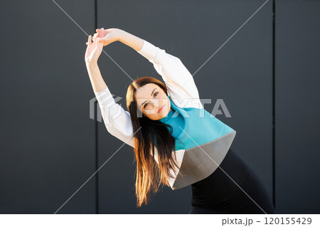 Cute sporty girl doing stretching on the street before training Cute sporty girl doing stretching on the street before training 120155429