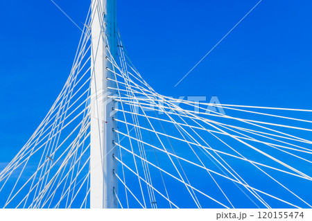 White metal cable-stayed bridge details are under clear blue sky 120155474