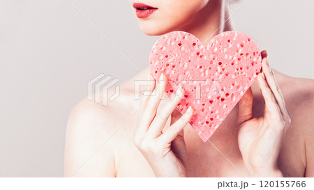 woman holding pink heart sponge in hands. 120155766