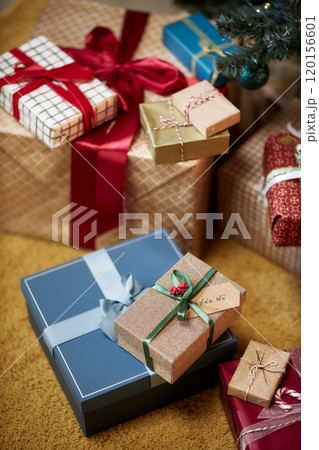 Vertical background image of colorful Christmas presents wrapped with bows piled under Christmas tree Vertical background image of colorful Christmas presents wrapped with bows piled under Christmas tree 120156601