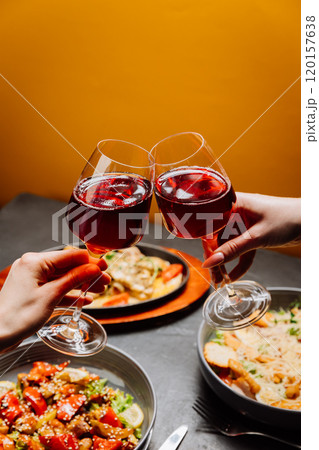 Celebrating with toast, two glasses of red wine clinking, setting the perfect mood for joyful meal 120157638