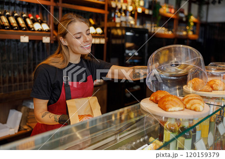 A Friendly Barista Serving Delicious Pastries in a Warm and Cozy Cafe Environment A Friendly Barista Serving Delicious Pastries in a Warm and Cozy Cafe Environment 120159379