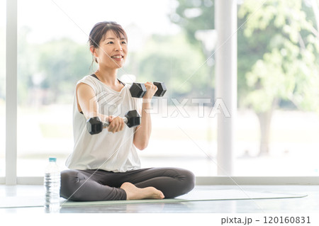 スポーツジムでダンベルを持って筋トレするスポーツウェアのアジア人の女性 120160831