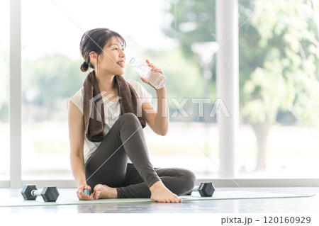 トレーニング後に水分補給するスポーツウェア姿の女性 120160929