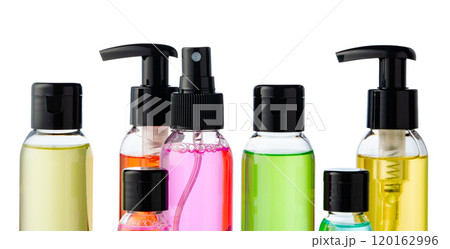 Various bottles with colored liquids and pumps arranged on white background 120162996