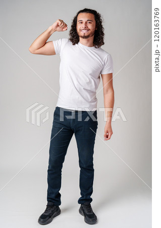Happy man celebrating success with raised fists in a studio against a plain background Happy man celebrating success with raised fists in a studio against a plain background 120163769
