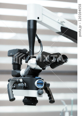 A detailed view of a dental microscope prepared for a procedure in a dental clinic A detailed view of a dental microscope prepared for a procedure in a dental clinic 120164058