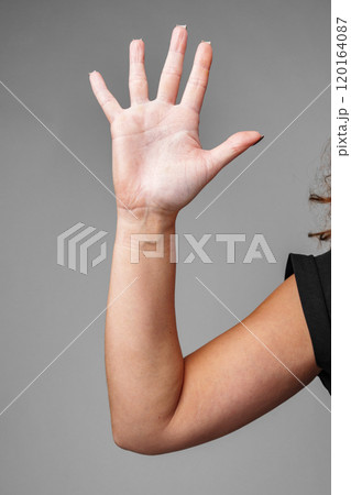 A raised hand demonstrating a gesture of greeting with a neutral background A raised hand demonstrating a gesture of greeting with a neutral background 120164087
