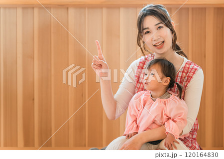 幼児の女の子を抱っこする保育士・保母さんの若いアジア人女性 120164830
