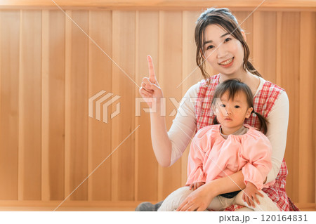 幼児の女の子を抱っこする保育士・保母さんの若いアジア人女性 120164831