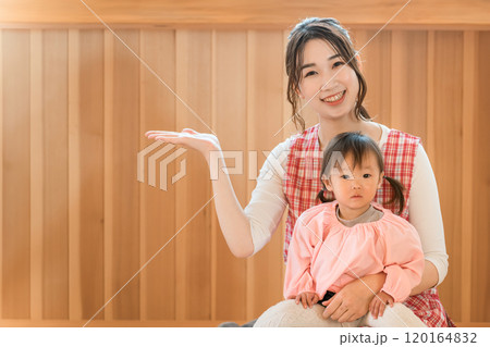 幼児の女の子を抱っこする保育士・保母さんの若いアジア人女性 幼児の女の子を抱っこする保育士・保母さんの若いアジア人女性 120164832