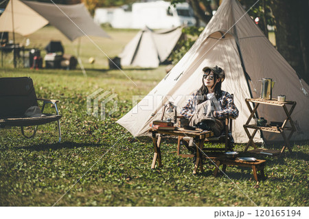 サングラスをしてテントの前に座る若い女性 サングラスをしてテントの前に座る若い女性 120165194