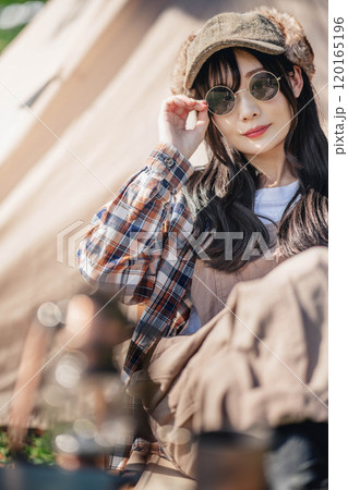 サングラスをしてテントの前に座る若い女性 サングラスをしてテントの前に座る若い女性 120165196