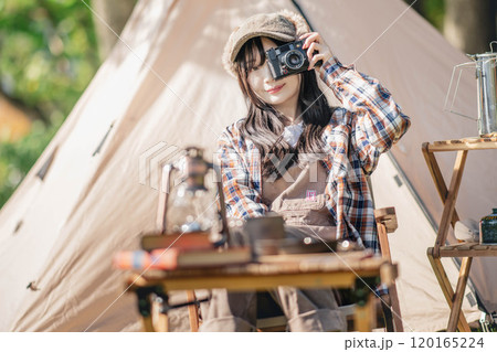 テントの前で座ってカメラを構える若い女性 テントの前で座ってカメラを構える若い女性 120165224
