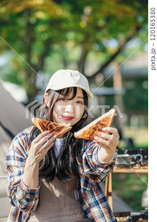キャンプ場で食事をとる女性 120165380