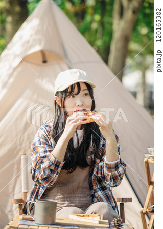 キャンプ場で食事をとる女性 120165382