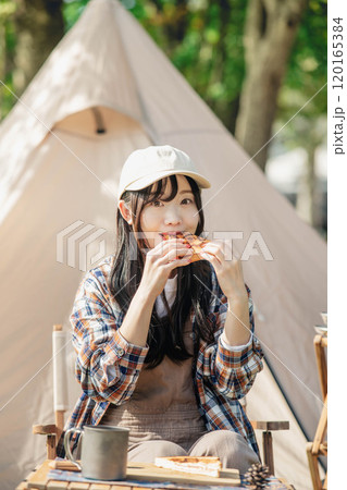 キャンプ場で食事をとる女性 120165384