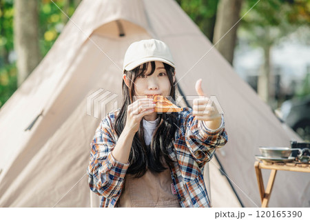 キャンプ場で食事をとる女性 120165390