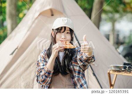 キャンプ場で食事をとる女性 120165391