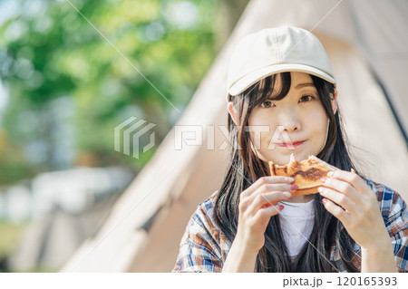 キャンプ場で食事をとる女性 120165393