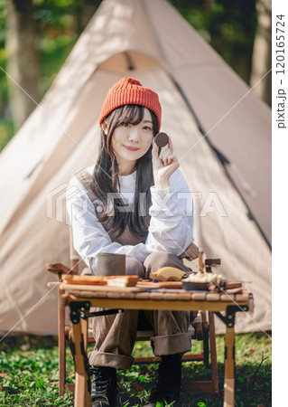 キャンプ場で飲食しながら休憩する女性 120165724