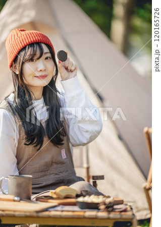 キャンプ場で飲食しながら休憩する女性 120165726