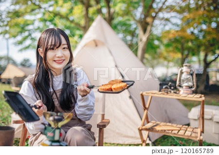 キャンプで食事を作る女性 120165789