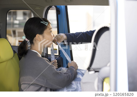 車の後部座席で買い物した荷物を受け取る子供　お手伝いイメージ 120165820