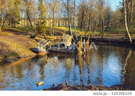 Dredger for cleaning reservoirs in autumn park. Dredger for cleaning reservoirs in autumn park. 120166328