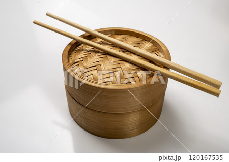 Chinese dim sum dumpling bamboo bowl basket with chopsticks isolated over white background 120167535