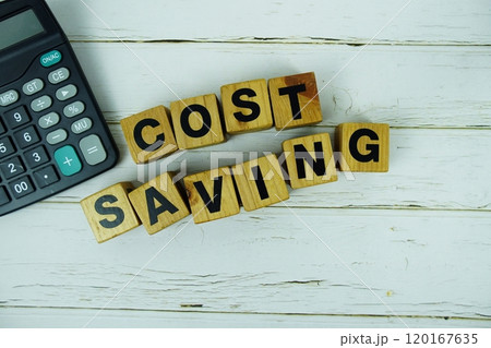 Cost Savings alphabet letters with calculator top view on wooden background Cost Savings alphabet letters with calculator top view on wooden background 120167635