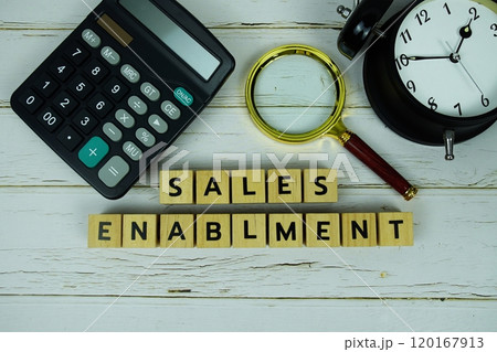 Sales Enablment with wooden blocks alphabet letters and magnifying glass, calculator, alarm clock top view on wooden background Sales Enablment with wooden blocks alphabet letters and magnifying glass, calculator, alarm clock top view on wooden background 120167913