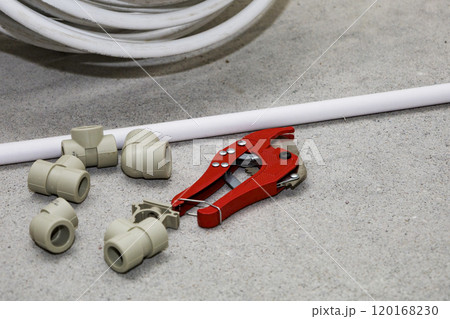 On the floor, there is a pair of metal wrenches and a pipe cutter 120168230