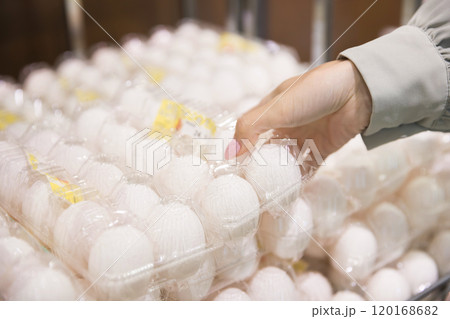 スーパーで卵パックを手に取る若い女性手元 スーパーで卵パックを手に取る若い女性手元 120168682