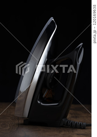 黒背景に配置されたアイロンのクローズアップ 120169638